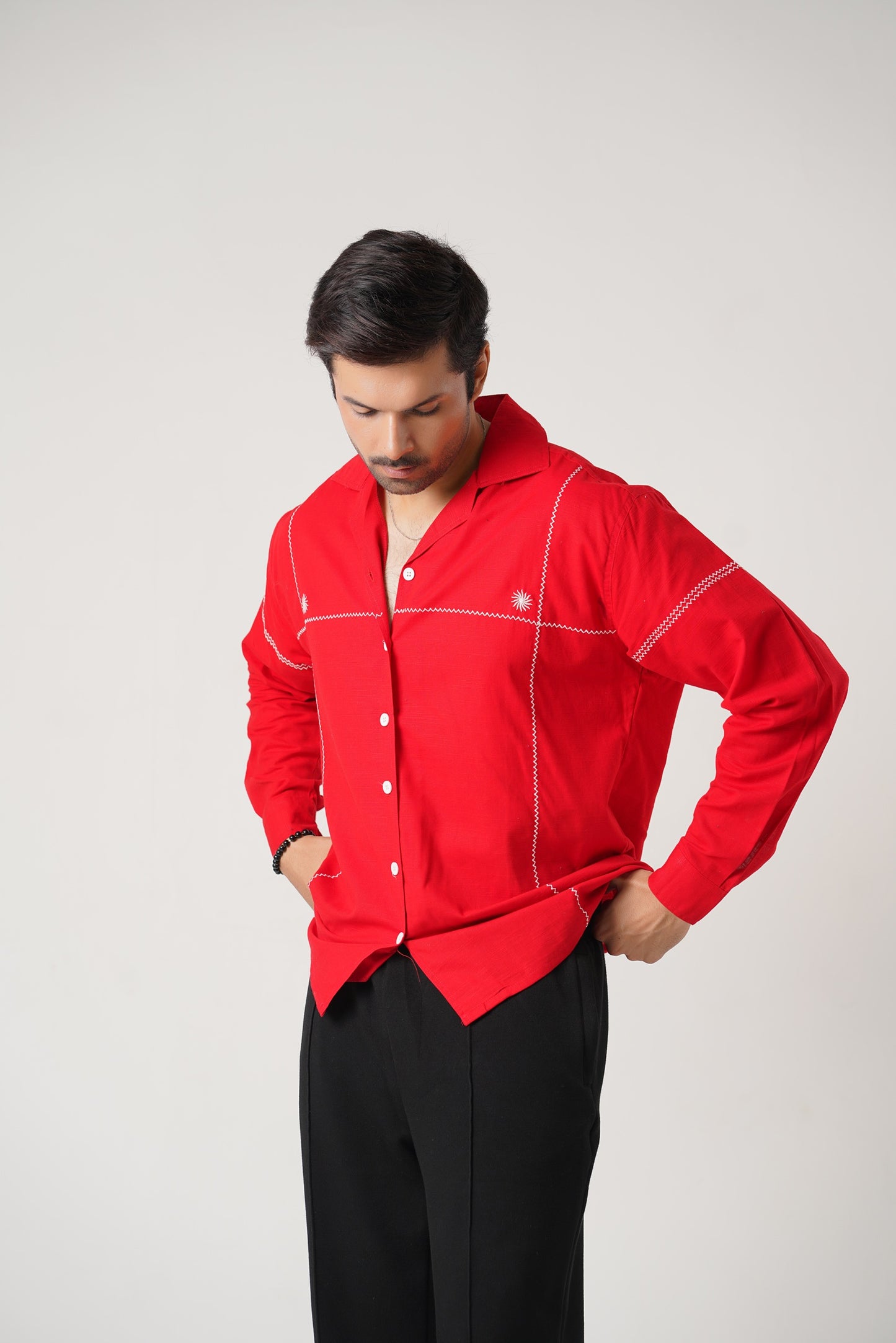 Man wearing a red shirt with white accents on a gray background
