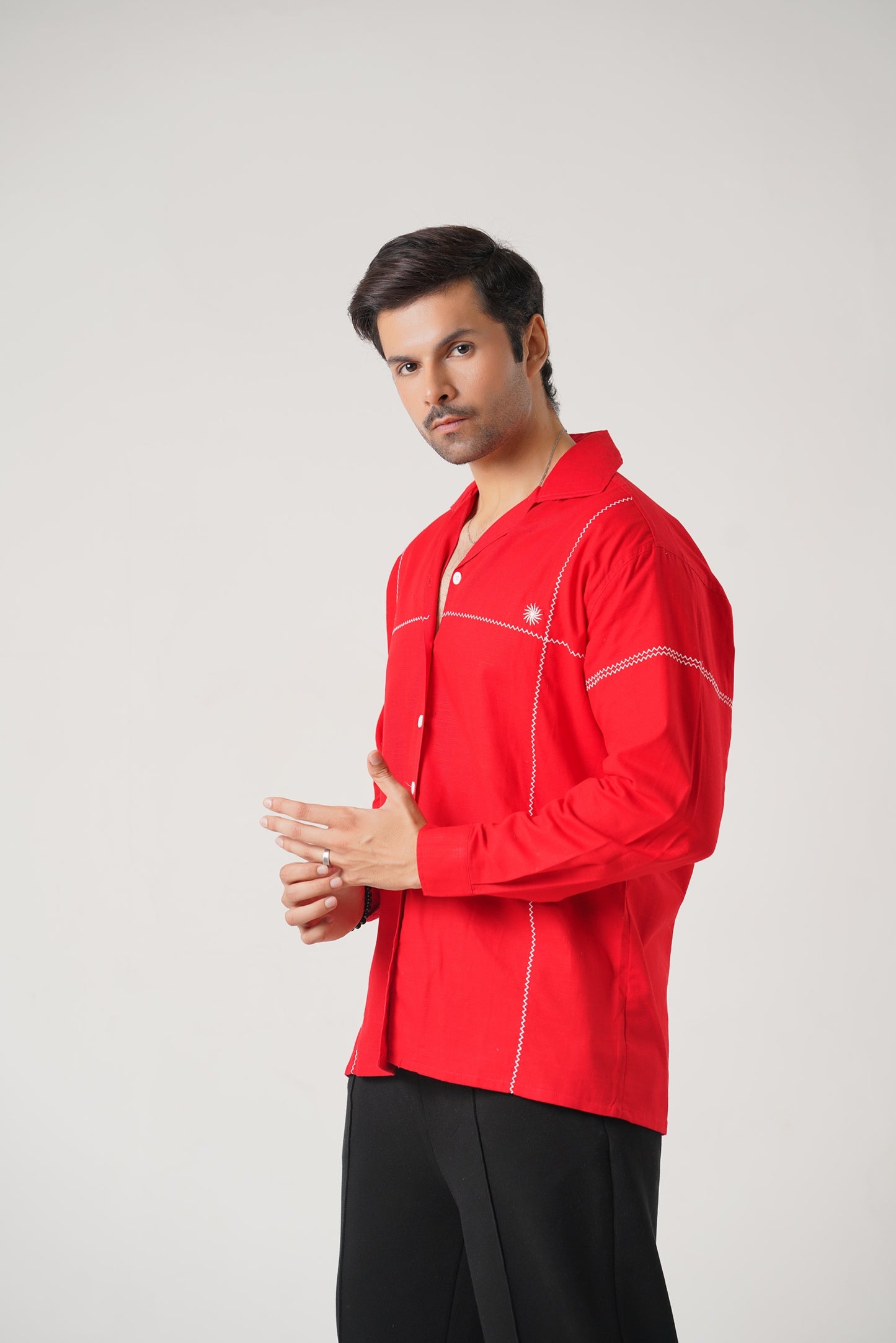 Man wearing a red shirt with white accents on a gray background