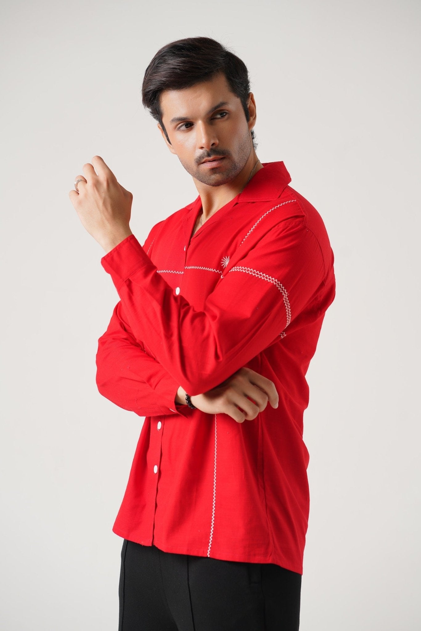 Man wearing a red shirt with white accents on a plain background