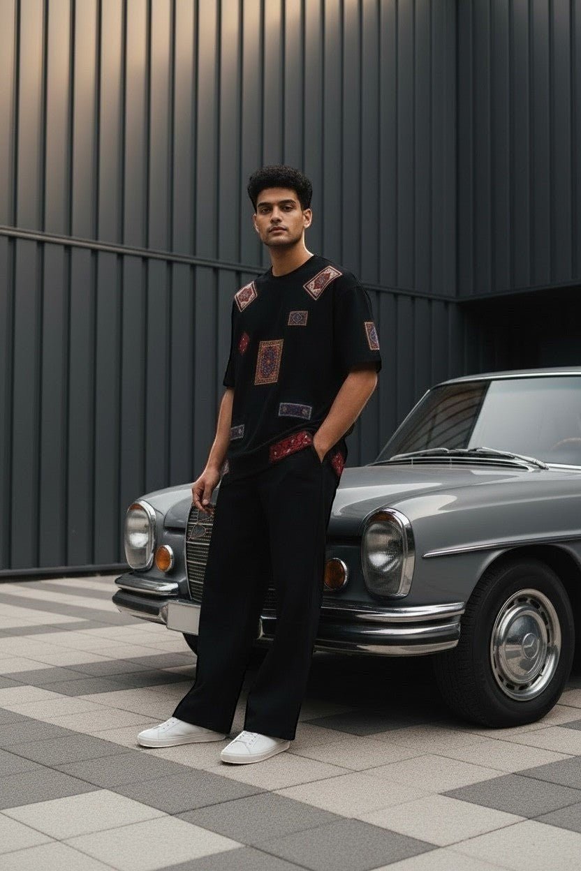 Koti Apparels black cotton t-shirt with patchwork oriental rug graphics on sleeves and hem. Model wears relaxed fit.