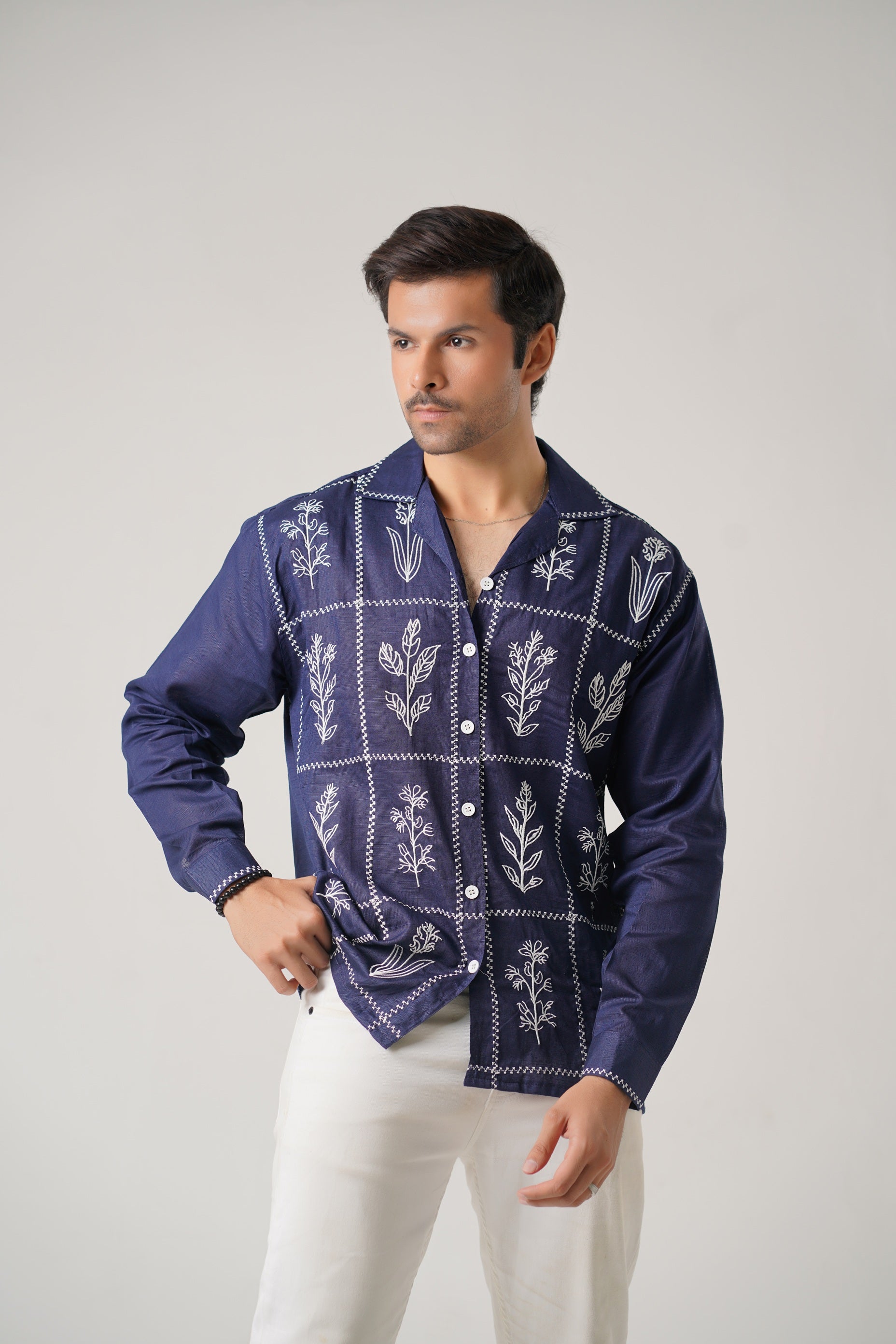 Man wearing a blue patterned shirt against a gray background