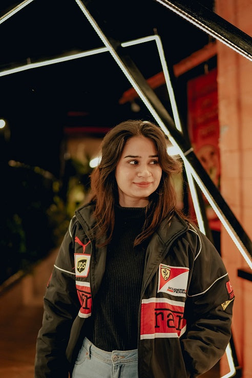Woman wearing a jacket with visible branding in an urban setting