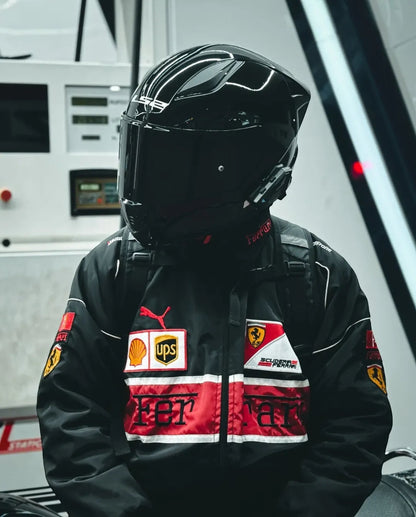 Koti Apparels black and red F1 Ferrari bomber jacket with embroidered logos, worn by a person in a black helmet.