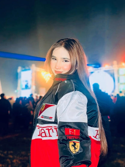 Koti Apparels Formula 1 Ferrari racing jacket in red, white, and black with embroidered logos. Features a woman wearing the jacket outdoors at night.