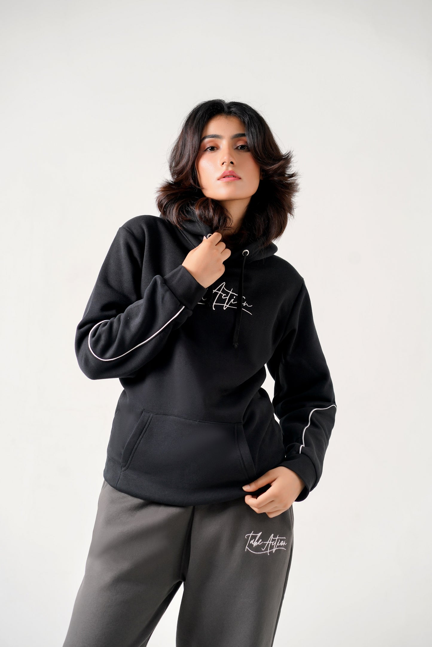 Person wearing a black hoodie with white text on a plain background