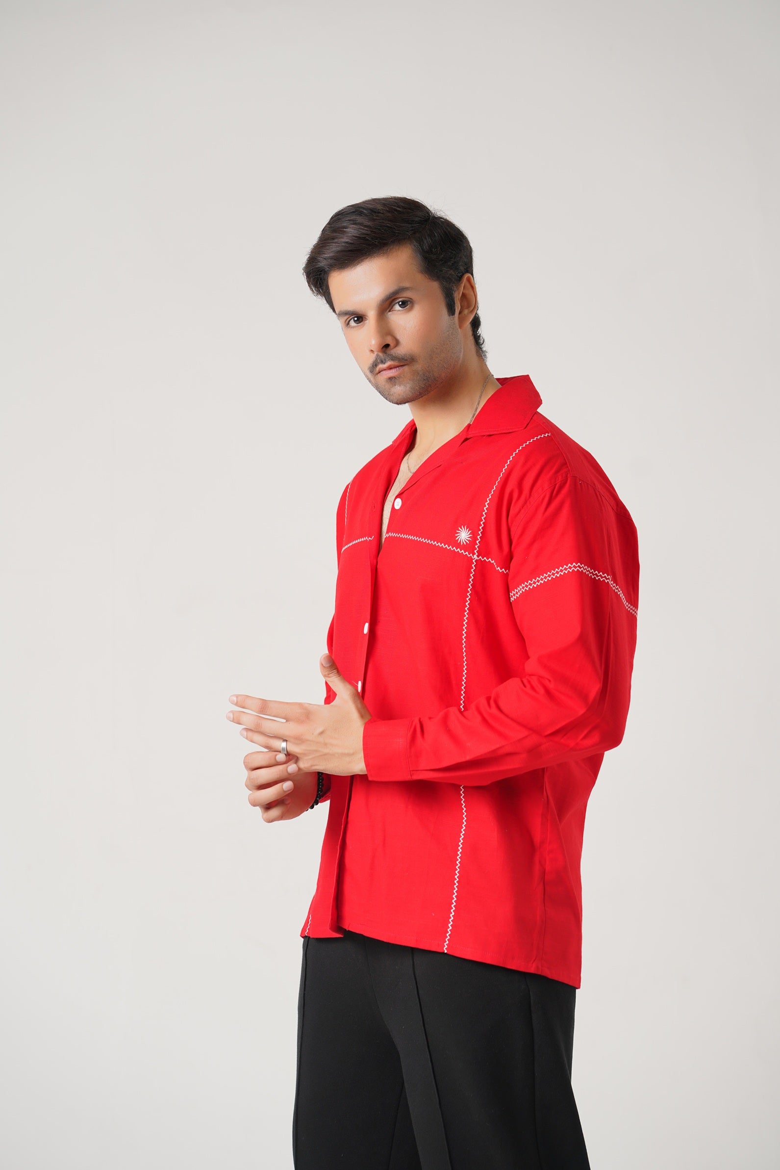 Man wearing a red shirt with white accents on a gray background