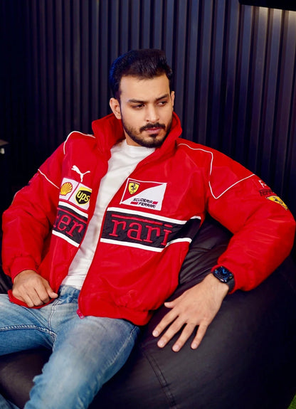 Koti Apparels red F1 Ferrari bomber jacket with embroidered logos and white accents, worn by a man with blue jeans.