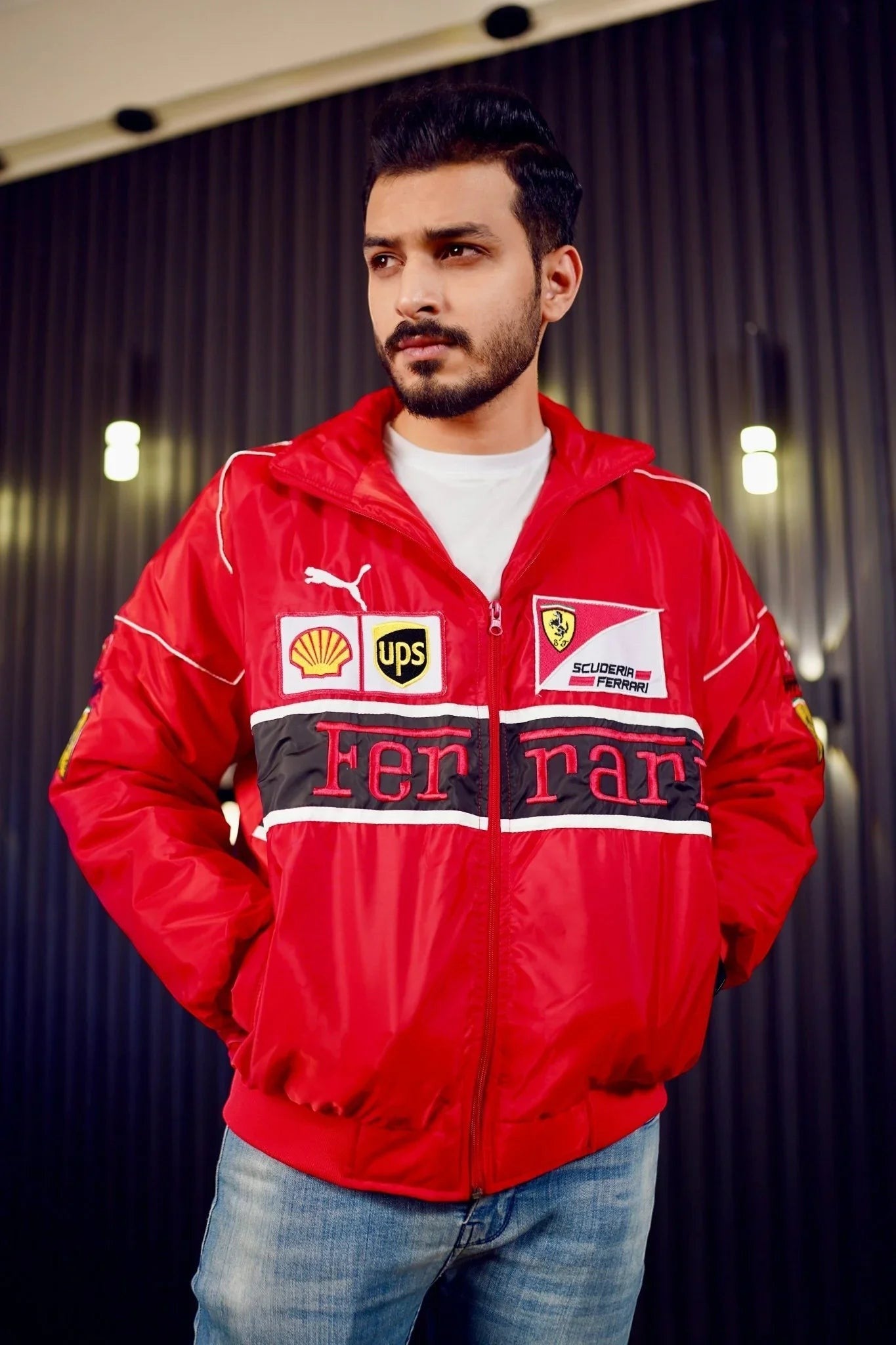 Koti Apparels red F1 Ferrari bomber jacket with embroidered logos and white trim, worn by a man with jeans.
