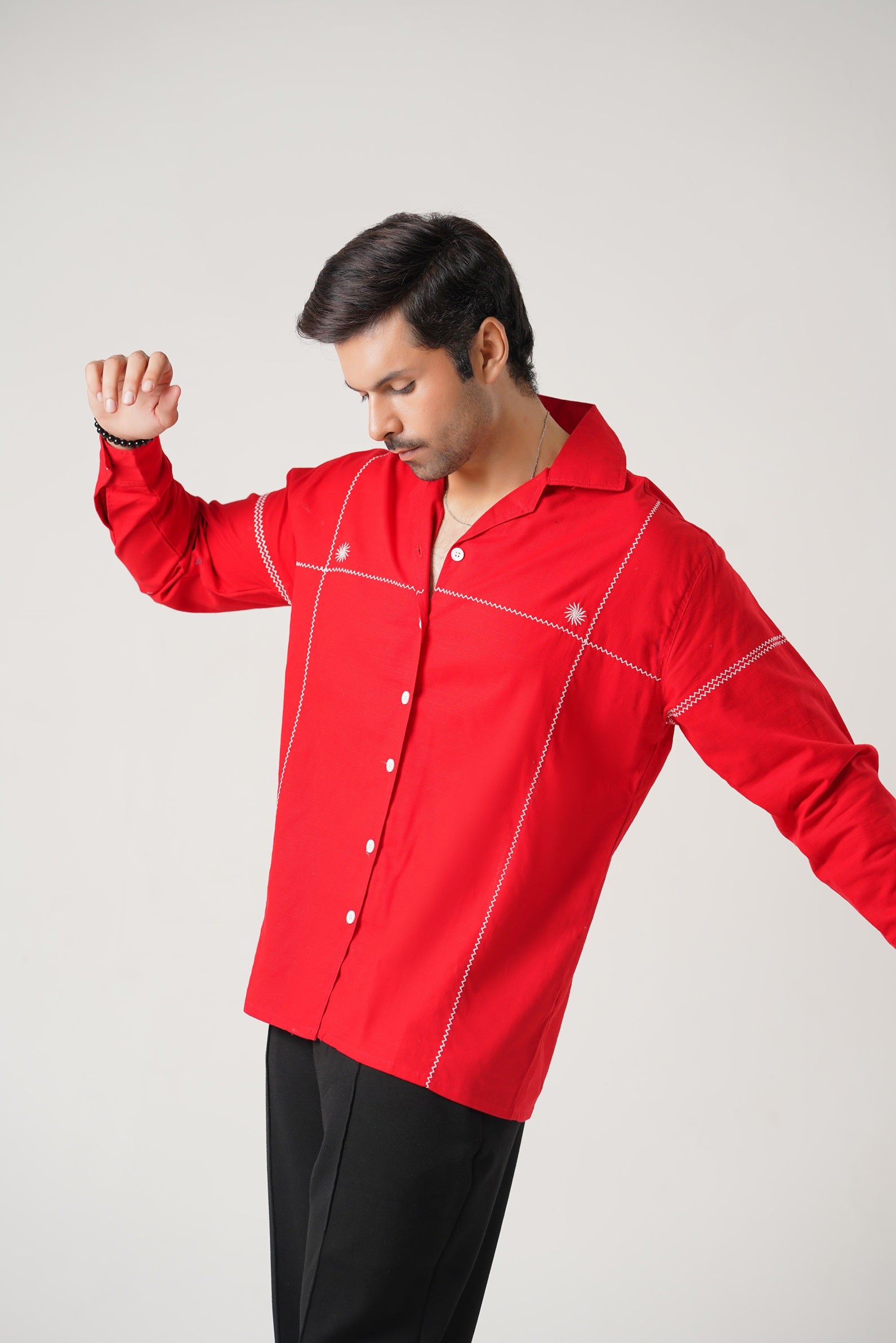 Man wearing a red shirt with white accents on a plain background