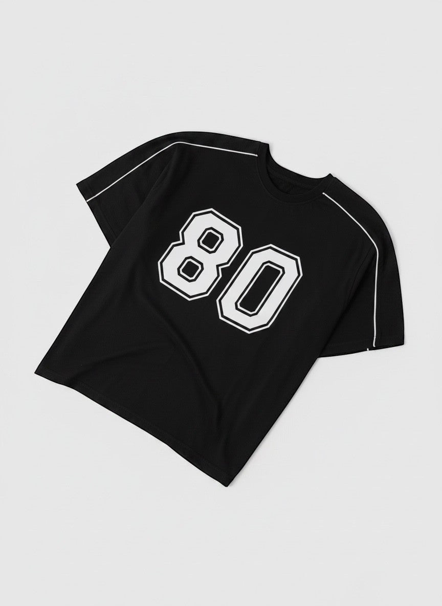 Koti Apparels black graphic baseball jersey t-shirt with white '80' graphic and white piping on shoulders and sleeves.