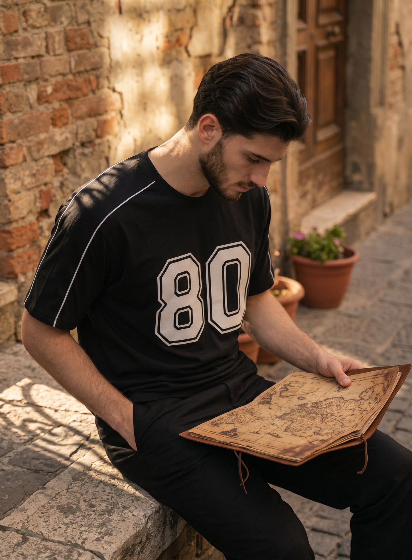 Koti Apparels black graphic baseball jersey with white 80 print and shoulder piping worn by a man reading a map