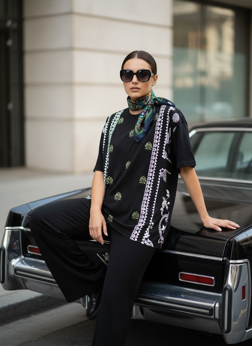 Koti Apparels black cotton blend t-shirt with graphic print featuring paisley and botanical motifs in green and white.