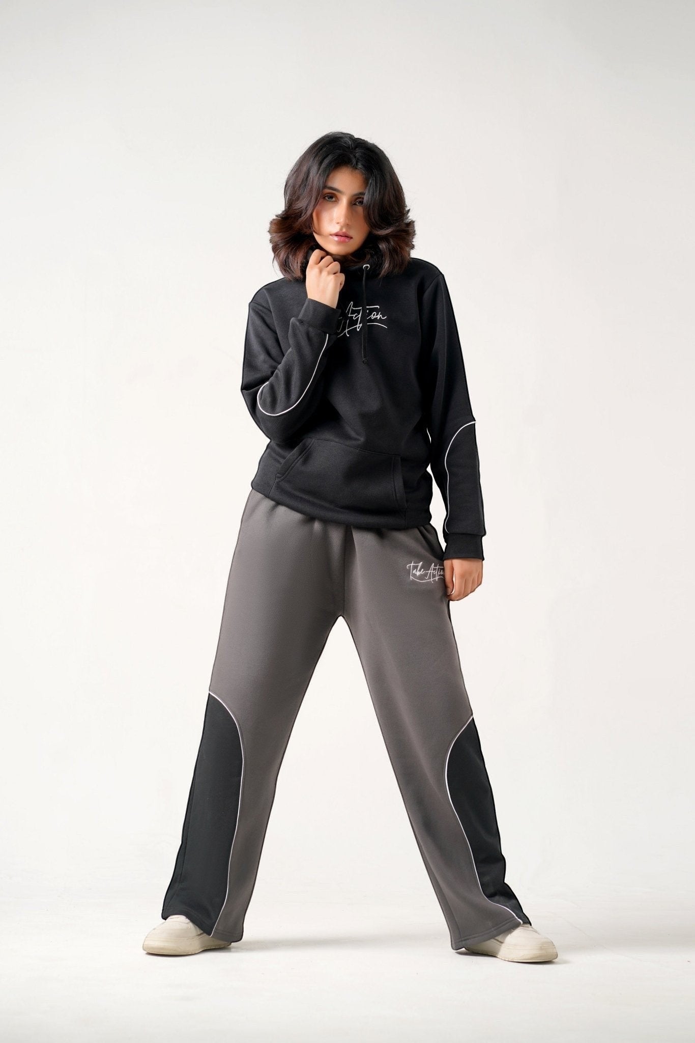 Koti Apparels black heavyweight cotton fleece hoodie with embroidered logo and grey trousers with black panels and embroidered logo.