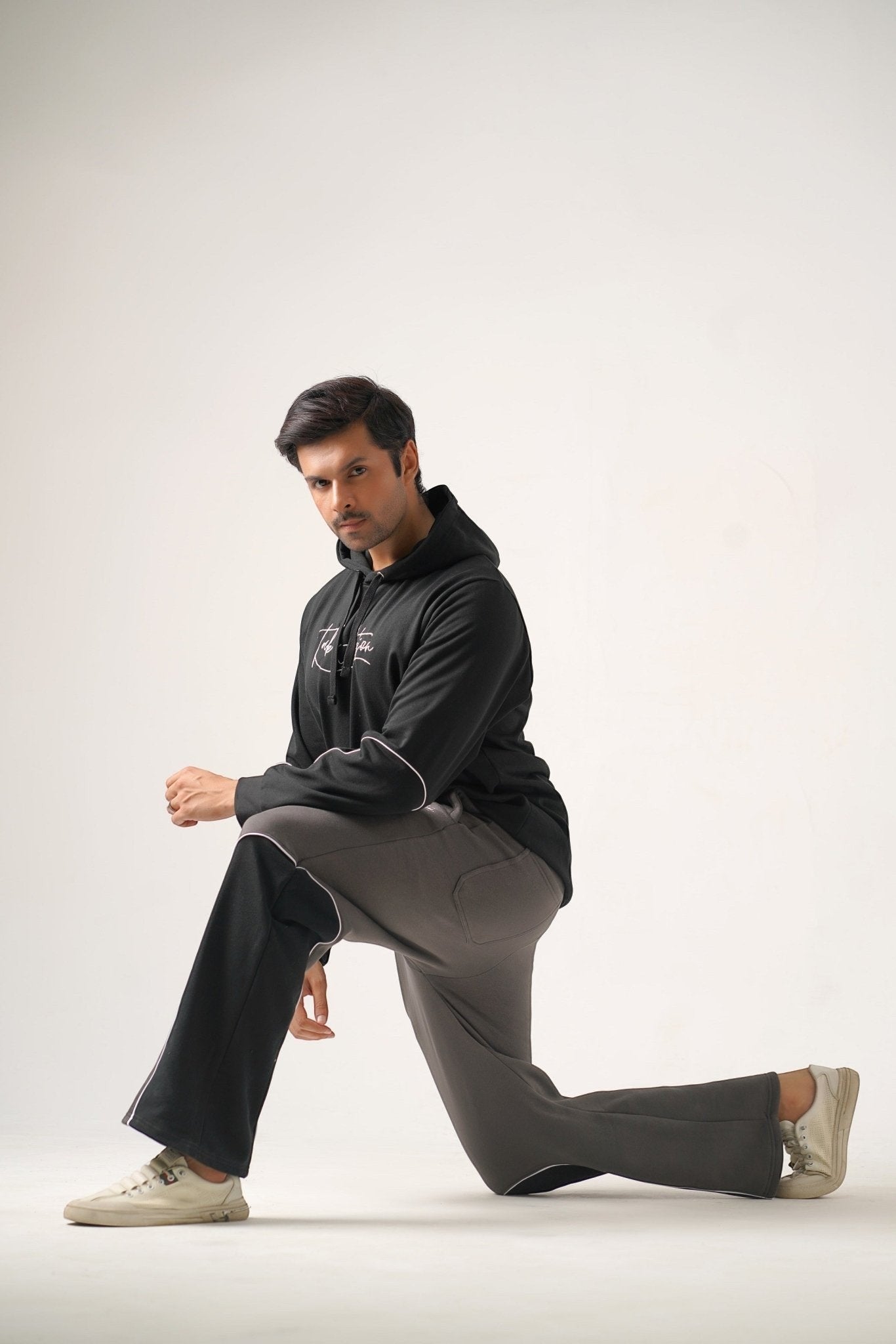 Koti Apparels black heavyweight fleece hoodie with embroidered logo and grey trousers with black side panels.