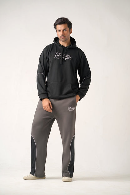 Koti Apparels black heavyweight cotton fleece hoodie with white embroidered logo and grey trousers with black and white panel details.