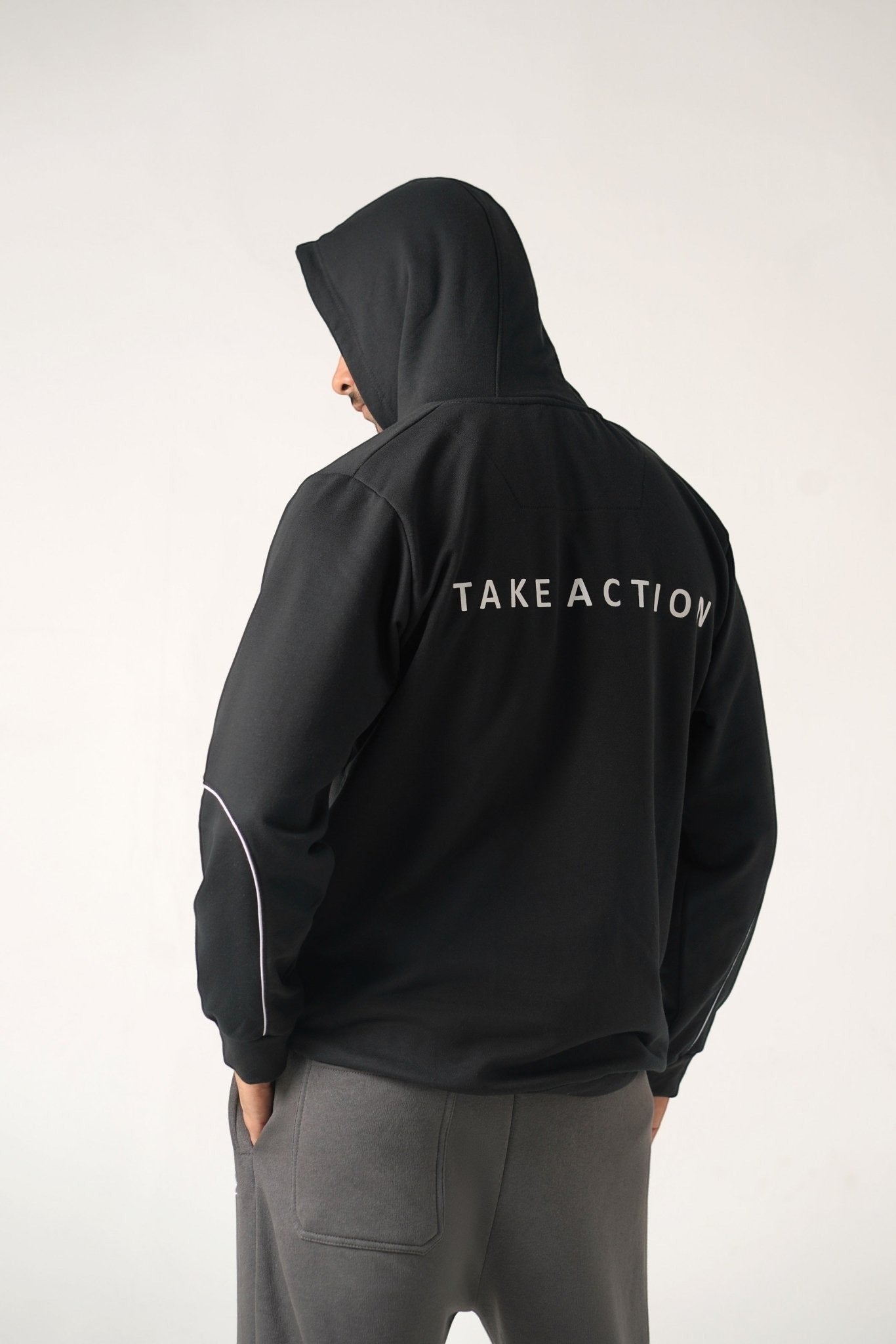 Koti Apparels black heavyweight cotton unisex hoodie with "TAKE ACTION" text on back and sleeve panel design.