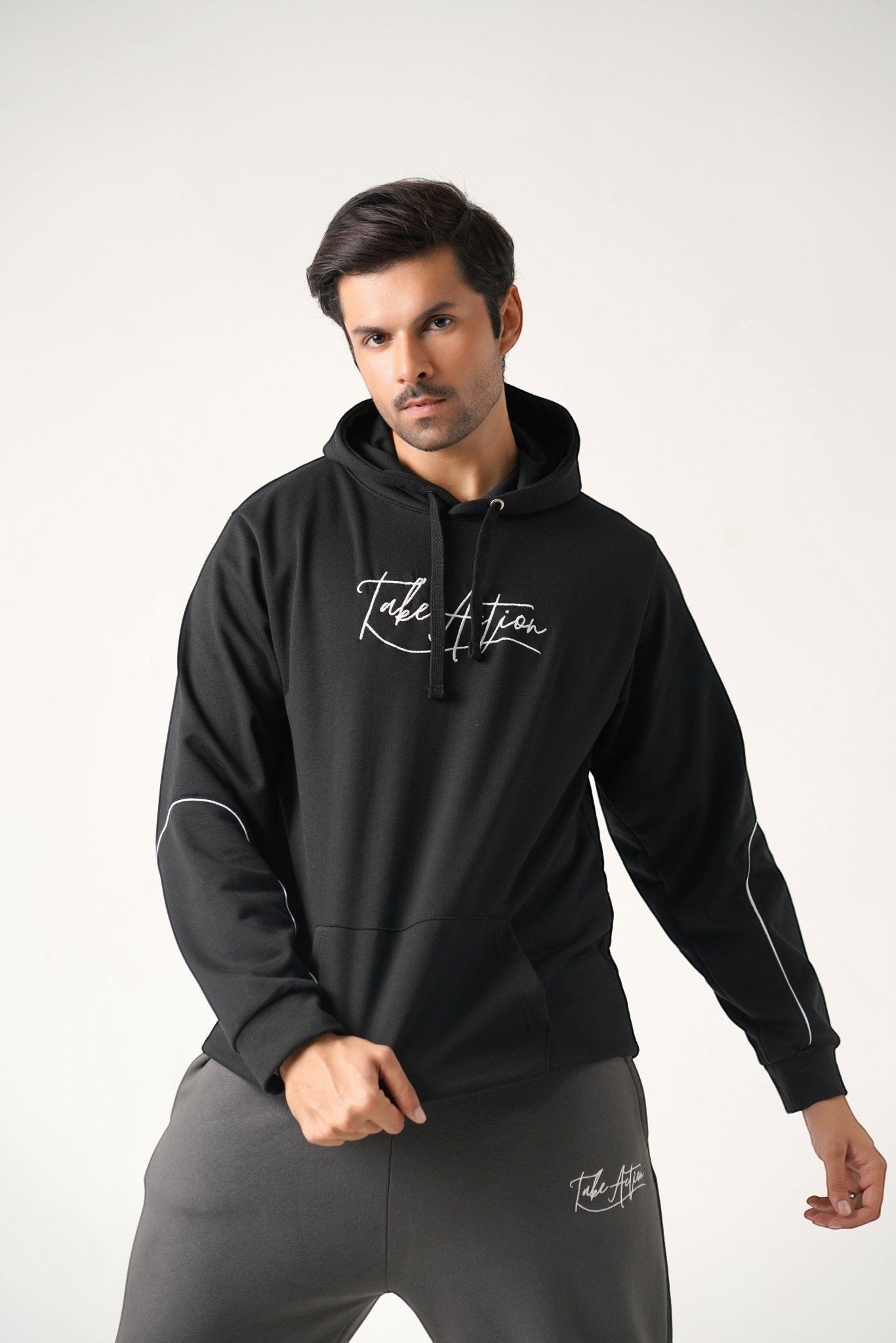 Koti Apparels black heavyweight cotton unisex hoodie with embroidered "TAKE ACTION" text on front and white piping on sleeves.