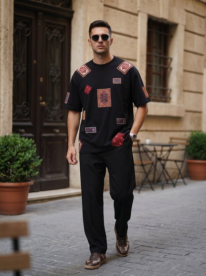 Koti Apparels black cotton t-shirt with vintage rug-inspired patchwork, worn by a man on a city street.