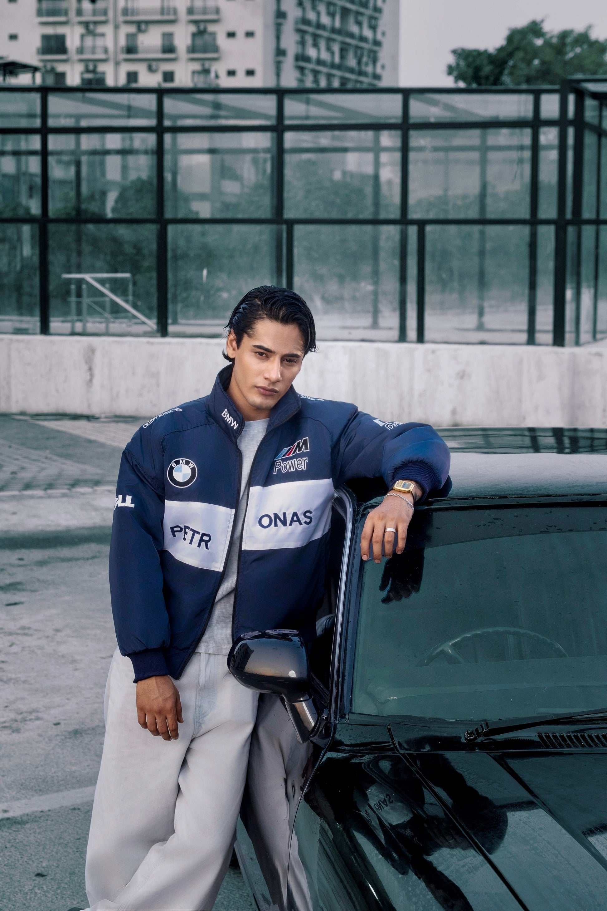 Koti Apparels BMW racing jacket in navy blue with white panels and embroidered motorsport logos worn by a man
