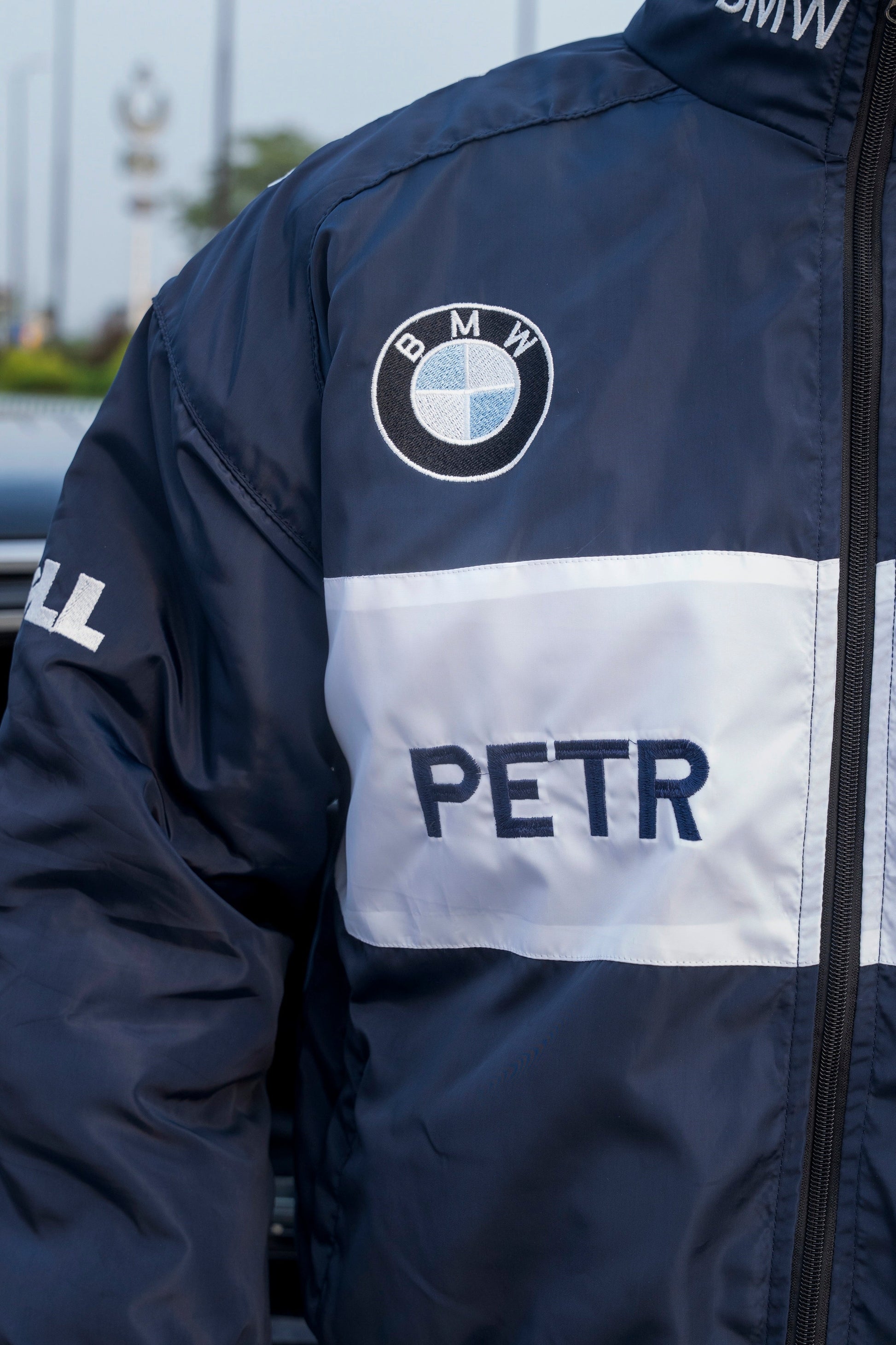 Koti Apparels navy blue BMW racing jacket featuring detailed embroidered logos and a white chest stripe