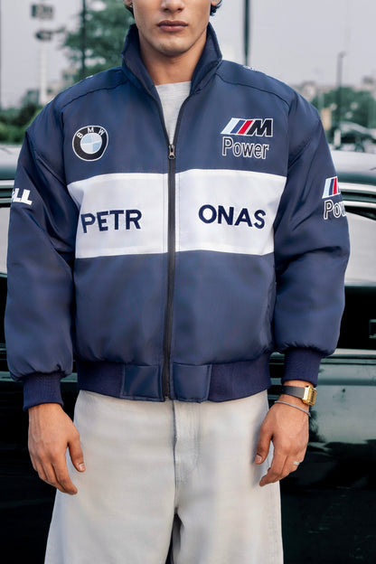 Model wearing a Koti Apparels navy blue BMW racing jacket with white chest stripe and embroidered motorsport logos