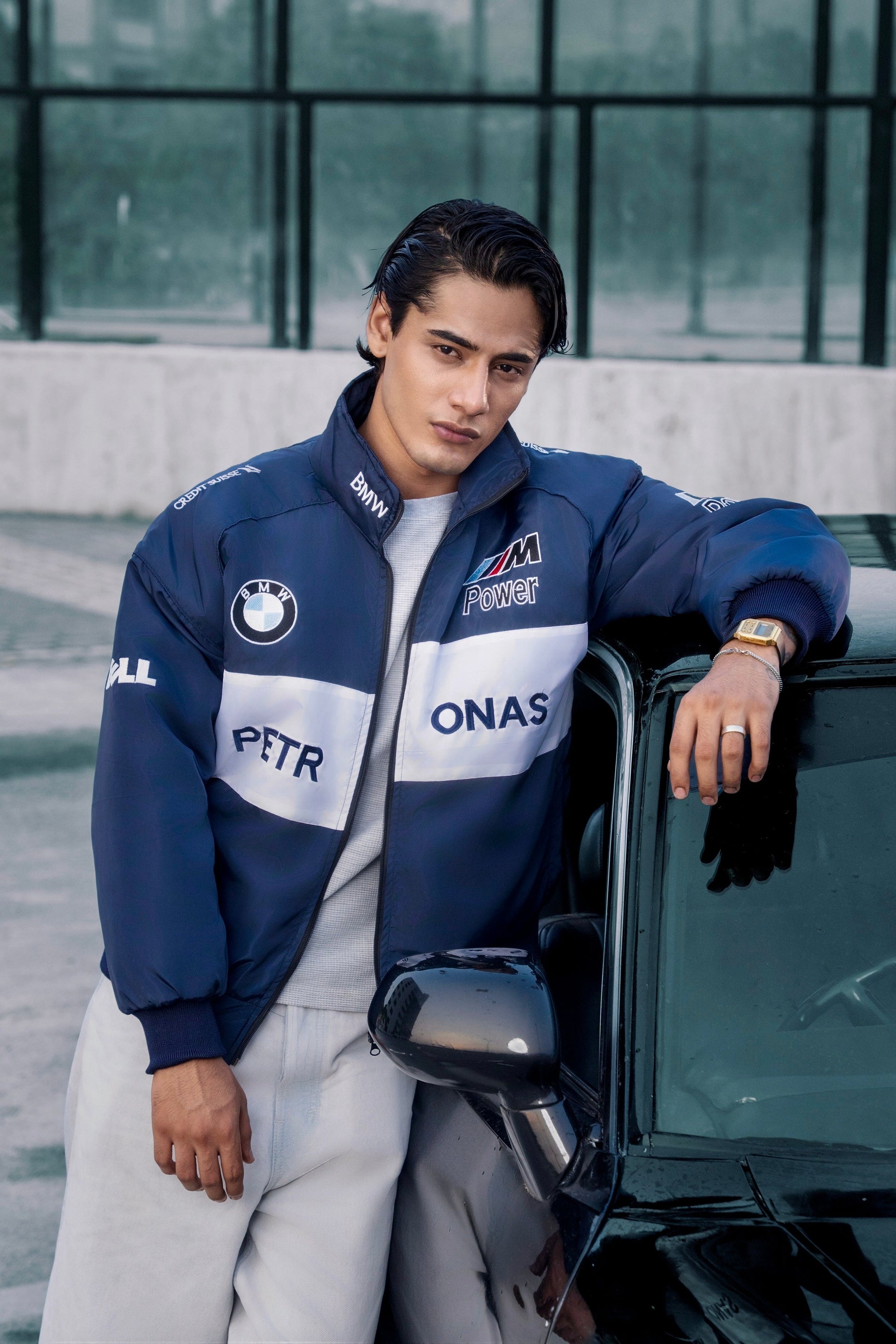 Koti Apparels BMW racing jacket in navy blue with white panels and embroidered motorsport logos worn by a man