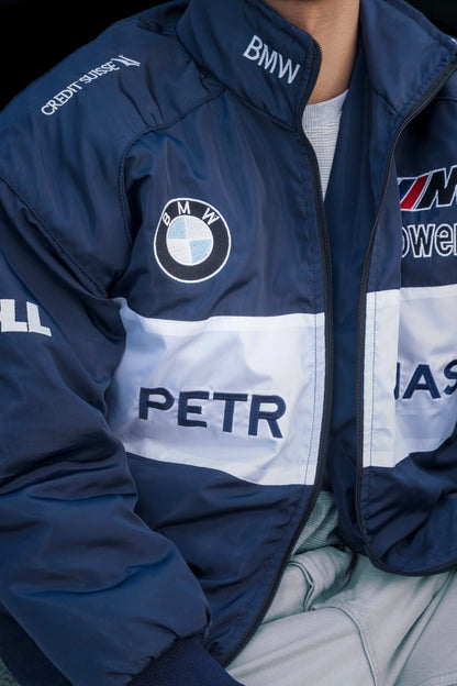 Koti Apparels navy blue BMW racing jacket featuring embroidered motorsport logos and a bold white chest stripe.