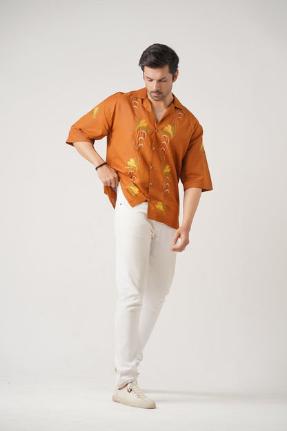 Koti Apparels burnt orange unisex shirt with floral embroidery, wooden buttons, and spread collar.