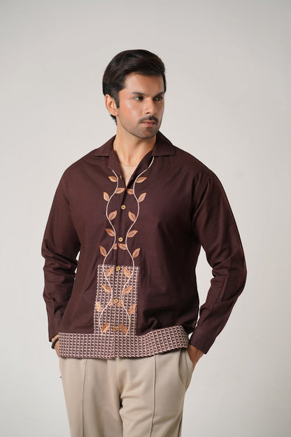 Koti Apparels unisex brown khaddar shirt with leaf embroidery on the placket and geometric pattern hem. Open collar, button-down front, full sleeves.