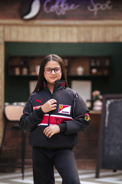 Young girl wearing a black Koti Apparels Scuderia Ferrari racing jacket with red and white details and team logos.