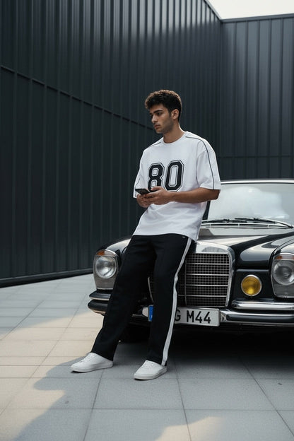 Koti Apparels white cotton blend t-shirt with black "80" graphic and black piping on seams.