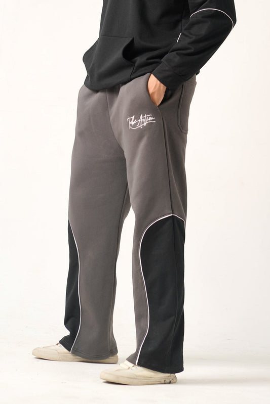 Koti Apparels heavyweight unisex winter fleece trousers in charcoal grey with black side panels and white piping, featuring embroidered 'TAKE ACTION' logo.