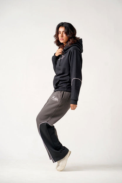 Koti Apparels unisex heavyweight fleece trousers in charcoal grey with black panels and white embroidery.