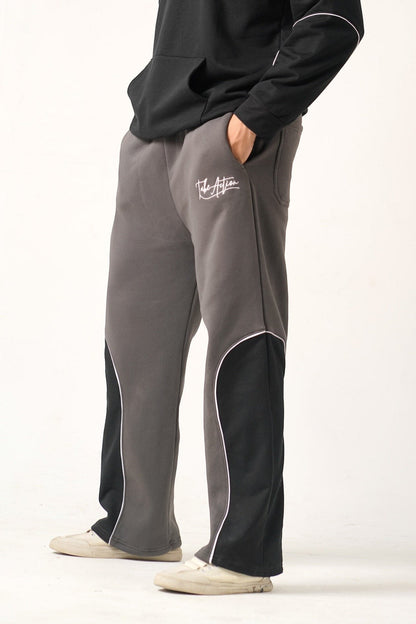 Koti Apparels heavyweight unisex winter fleece trousers in charcoal grey with black side panels and white piping. Embroidered 'TAKE ACTION' logo.