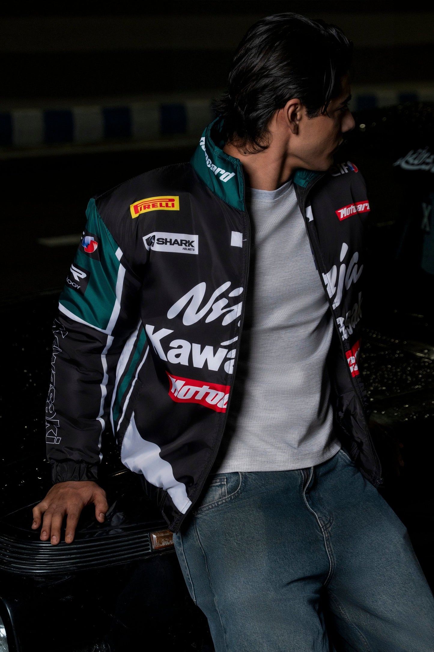 Man wearing a Koti Apparels Kawasaki racing jacket in black and green with sponsor logos and polyester construction