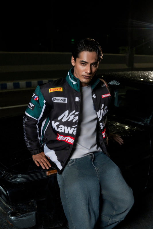Koti Apparels Kawasaki racing jacket in black and green polyester worn by a man leaning against a car at night
