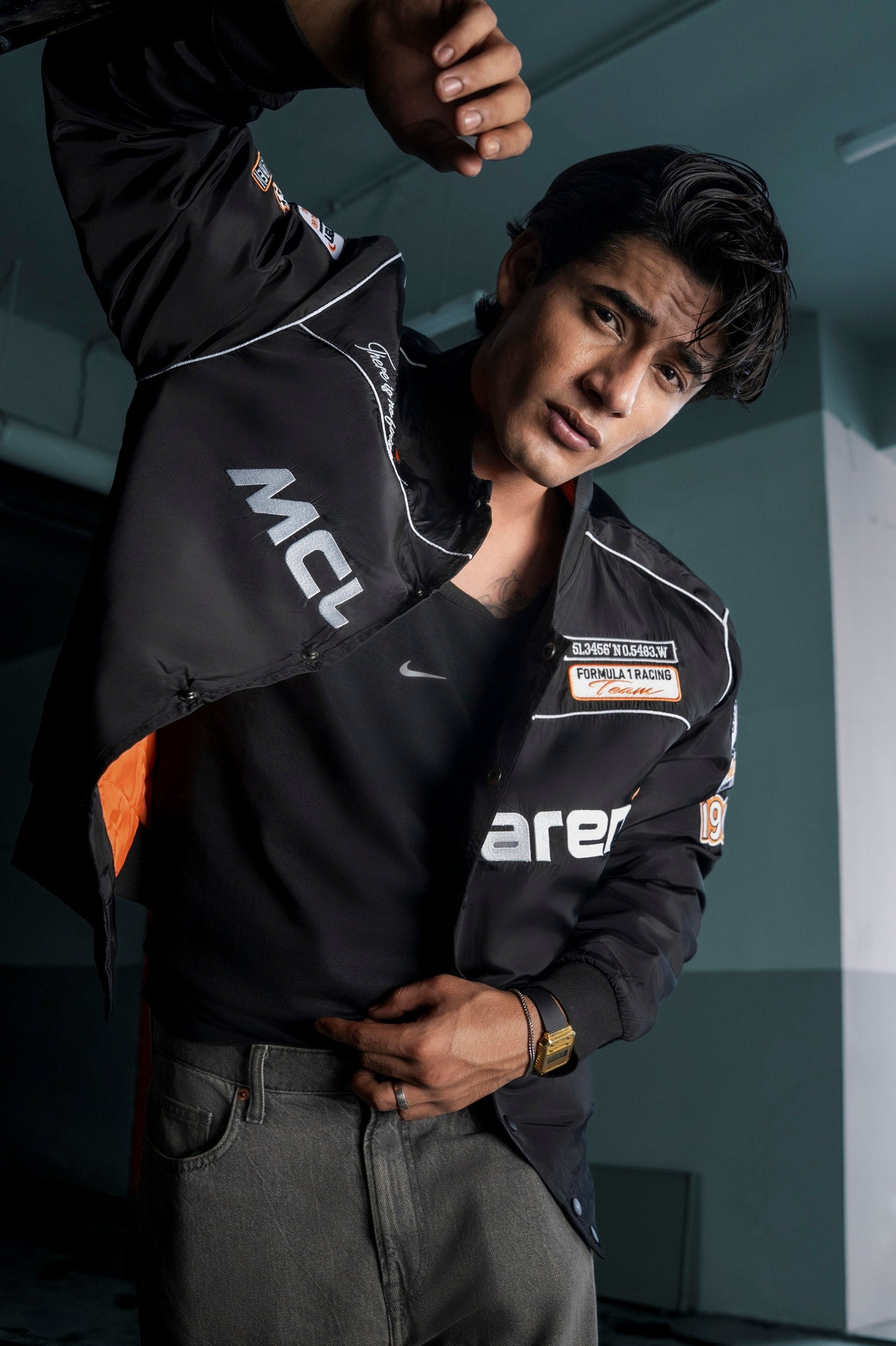 Koti Apparels McLaren F1 jacket in black with premium needle embroidery, worn by a man in a studio setting.