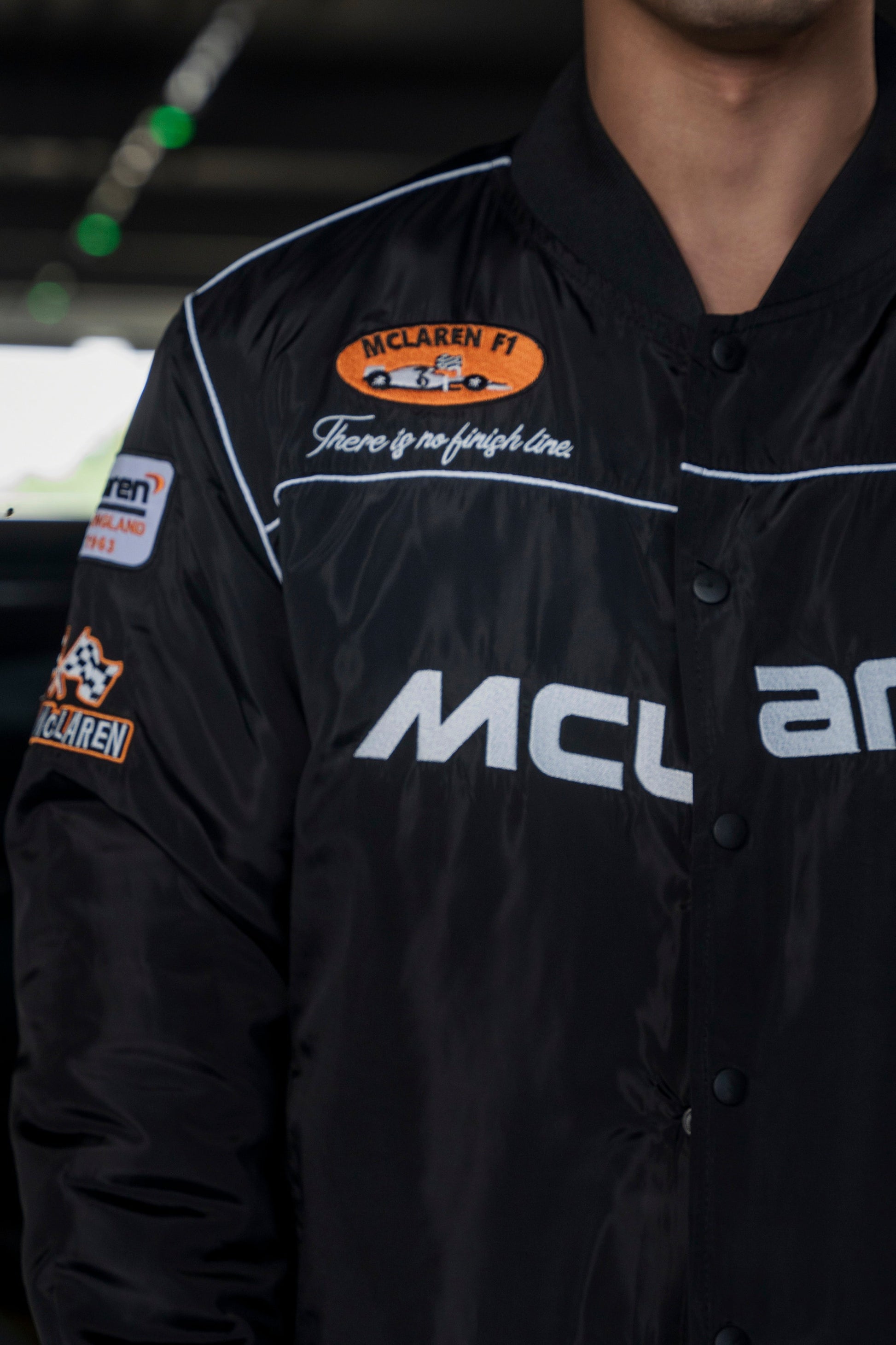 Koti Apparels black McLaren F1 racing jacket with premium needle-embroidered logos and full-zip front closure.