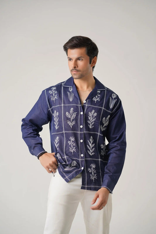 Koti Apparels navy blue cotton khaddar unisex shirt with ivory-white floral embroidery in a grid pattern, open collar, and button-down front.
