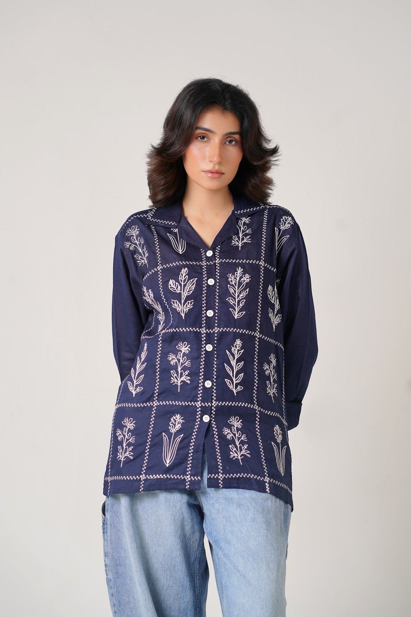 Koti Apparels navy blue cotton khaddar unisex shirt with ivory-white floral embroidery in a grid pattern. Open collar, button-down front, full sleeves.