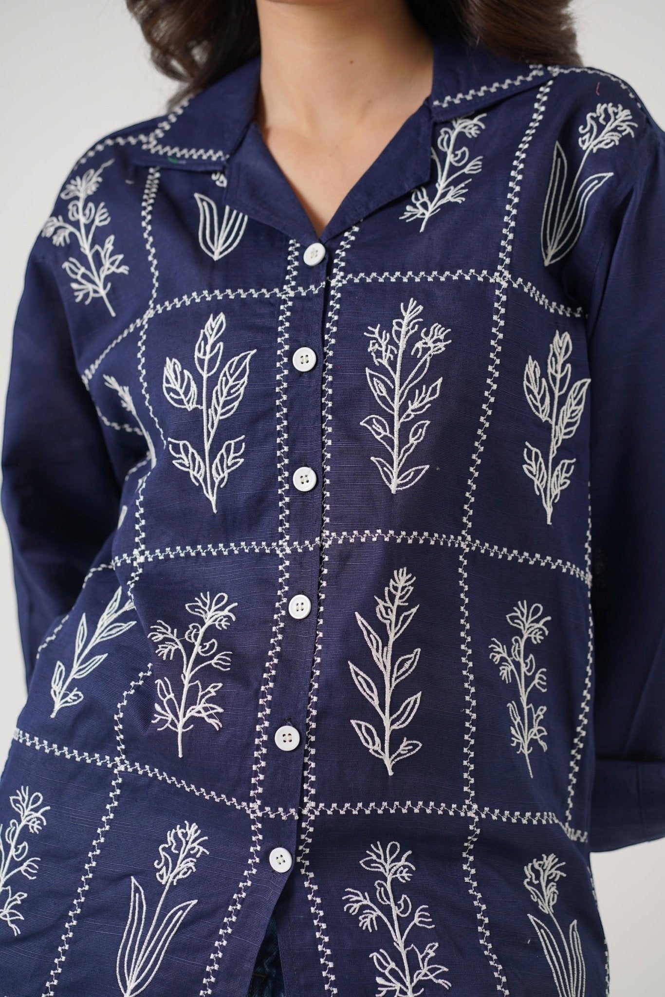Koti Apparels navy blue cotton khaddar unisex shirt with white floral embroidery in a grid pattern, open collar, and button-down front.