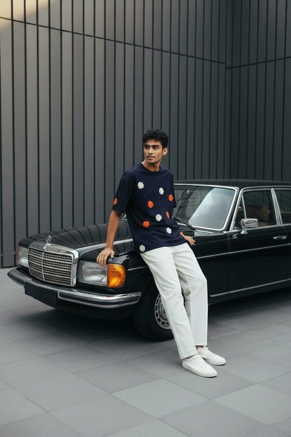 Koti Apparels navy blue short sleeve t-shirt with embroidered orange and white floral appliques. Model wears white trousers.