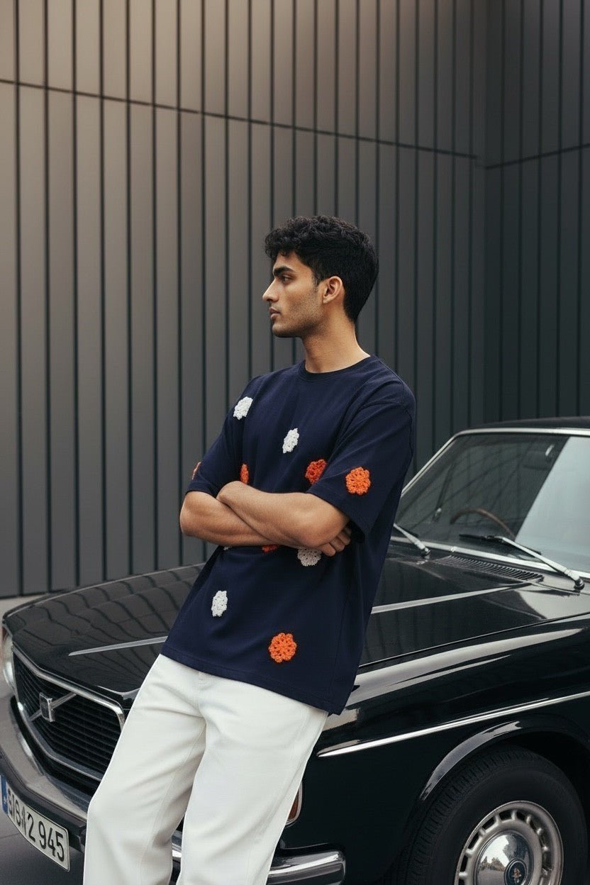 Koti Apparels navy blue t-shirt with embroidered orange and white floral appliques, short sleeves, crew neck, worn by a man.