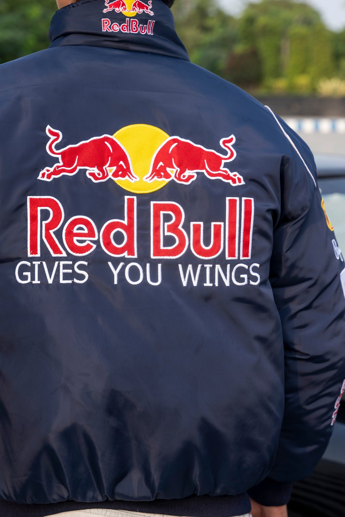 Koti Apparels navy blue Red Bull racing jacket with large embroidered team logo and Gives You Wings slogan on back