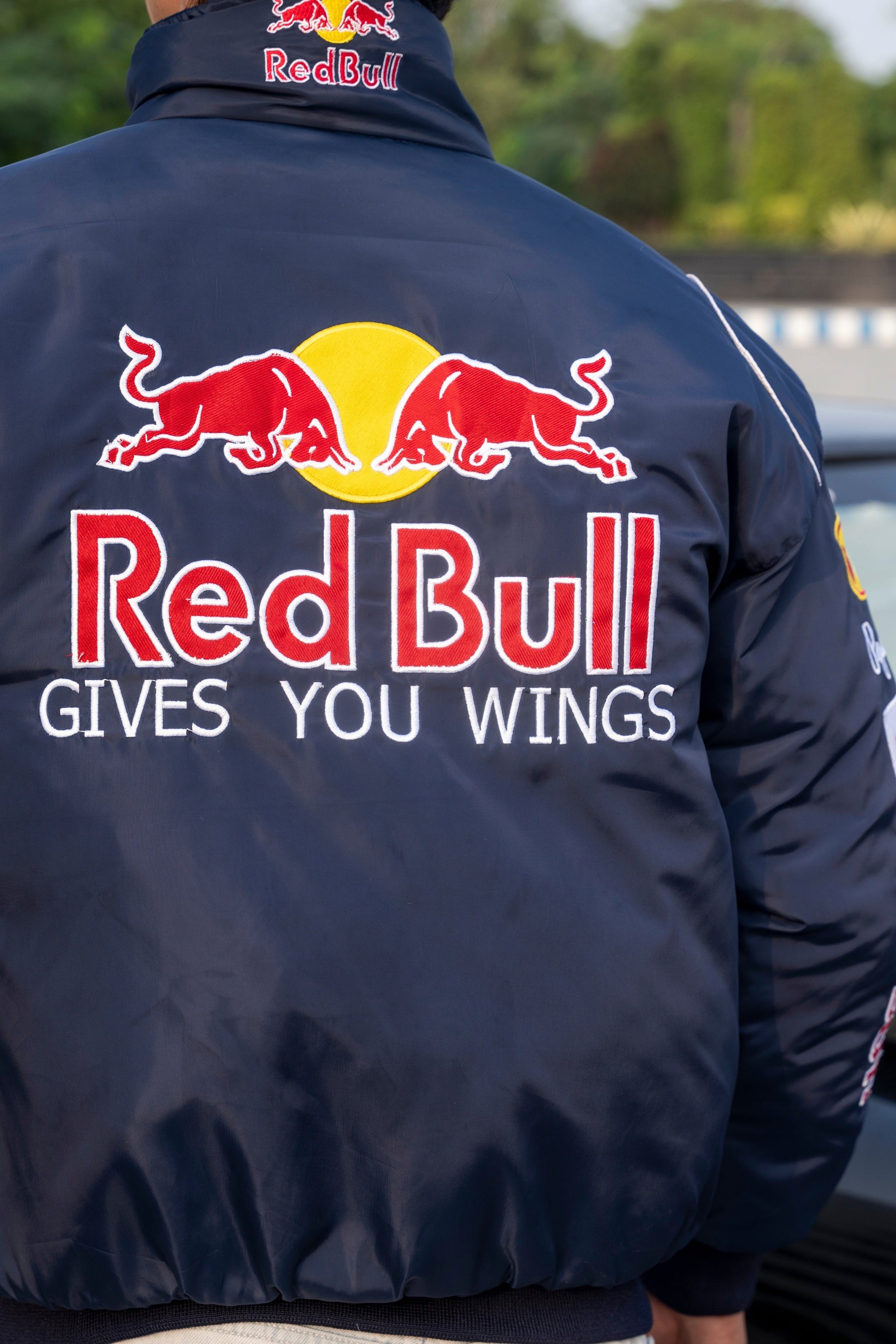 Koti Apparels navy blue Red Bull racing jacket with large embroidered team logo and Gives You Wings slogan on back
