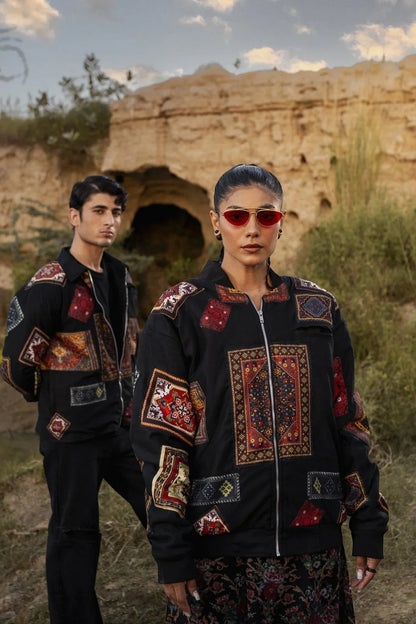 Koti Apparels black canvas bomber jacket with multicolour patchwork panels featuring intricate traditional patterns, zipper closure, and front pockets.