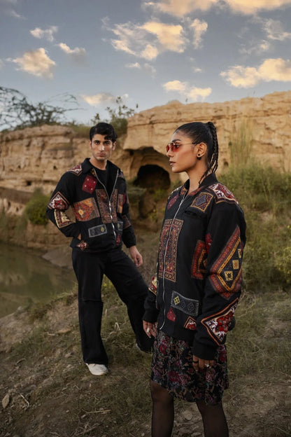Koti Apparels black canvas jacket with multicolour patchwork panels, zip-up front, and side pockets. Worn by a woman with sunglasses.
