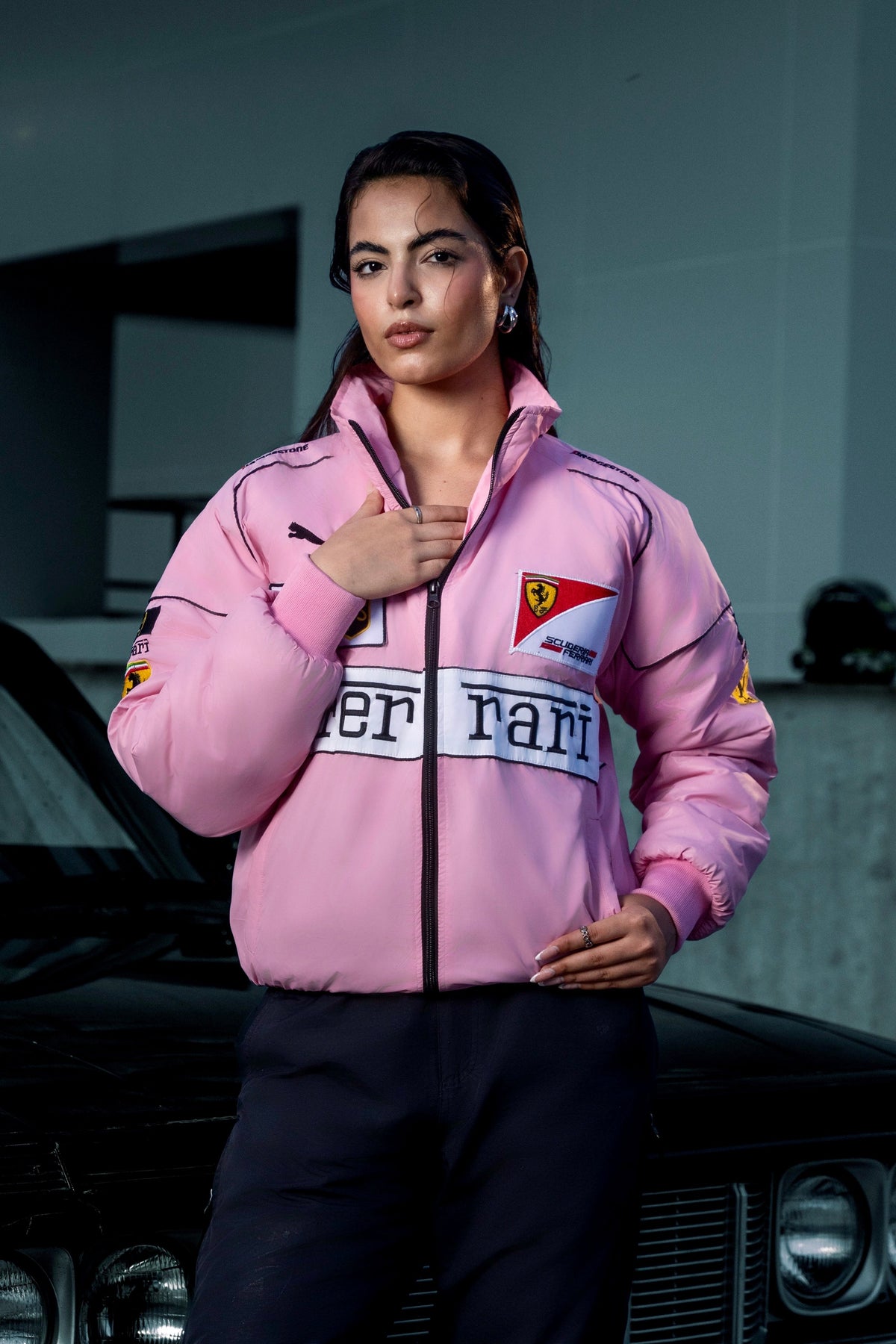 Model wearing a Koti Apparels pink Ferrari racing jacket with embroidered logos and a high collar.