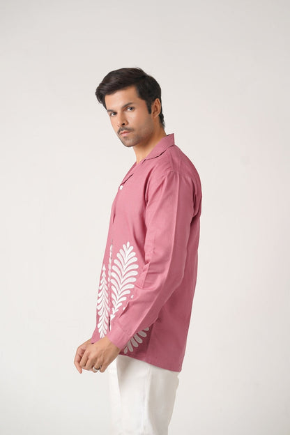 Koti Apparels rose pink unisex shirt with full sleeves and white leaf embroidery on the hem. Model wears white pants.