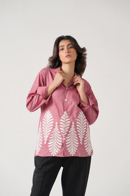 Koti Apparels rose pink unisex shirt with full sleeves and leaf embroidery on the hem. Model wears black trousers.